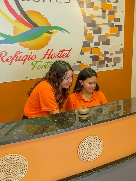 As recepcionistas Vitória e Alice na recepção da Refúgio Pousada Fortaleza