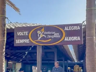 Na foto, vemos a entrada e saída do acolhedor restaurante Delícias das Jangadas, ponto de apoio para o passeio de Águas Belas organizado pelo Refúgio Hostel Fortaleza & Pousada. Com o slogan "Volte Sempre com Alegria", o restaurante convida os visitantes a desfrutar de sua hospitalidade e sabores típicos do Ceará. É aqui que nossos hóspedes fazem uma pausa para relaxar, recarregar as energias e saborear uma deliciosa refeição durante o passeio. Este ponto de parada faz parte da experiência completa que oferecemos: momentos de tranquilidade e conexão com a cultura local em meio à beleza paradisíaca de Águas Belas.